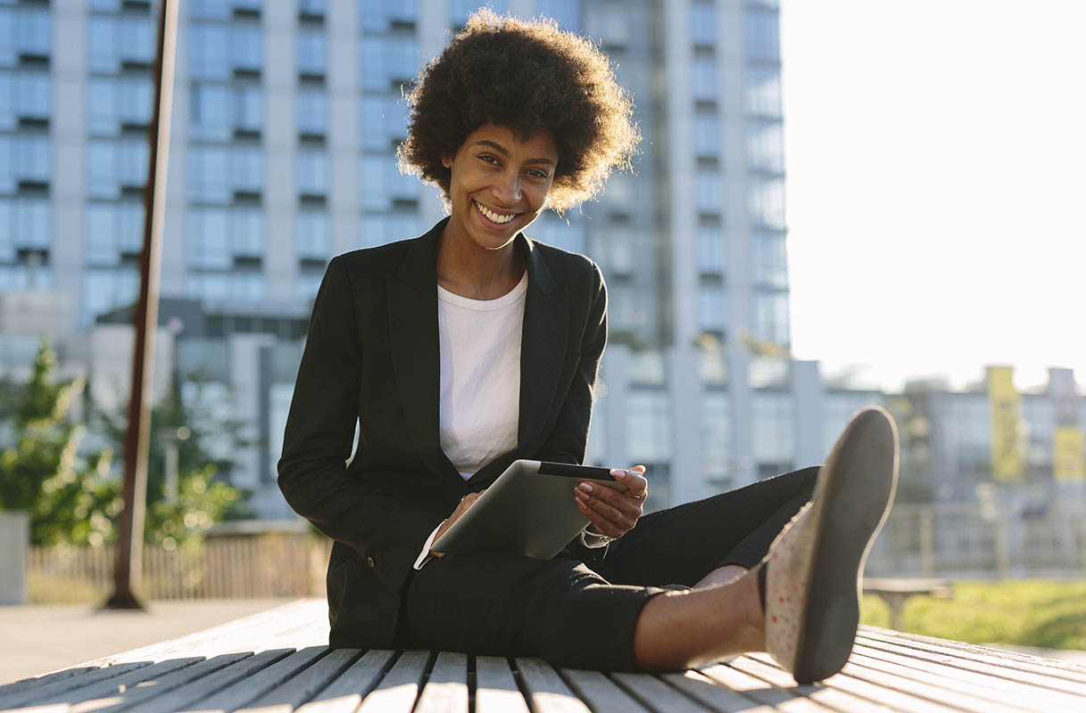 Woman sitting with laptop outside in the city